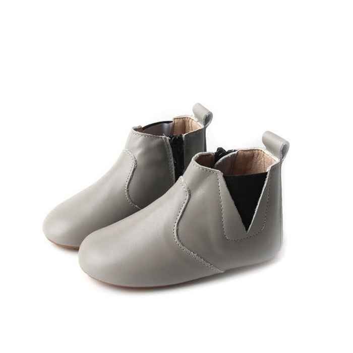 Light grey coloured leather toddler boots. View of the pair from the side. Features elastic ankle closure one side, zip closure opposite side.